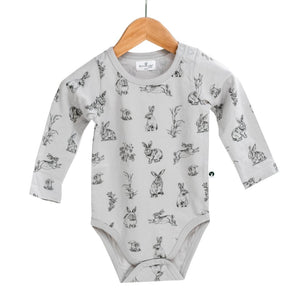 Grey long sleeve organic baby onesies with rabbit print and a dome on each shoulder.