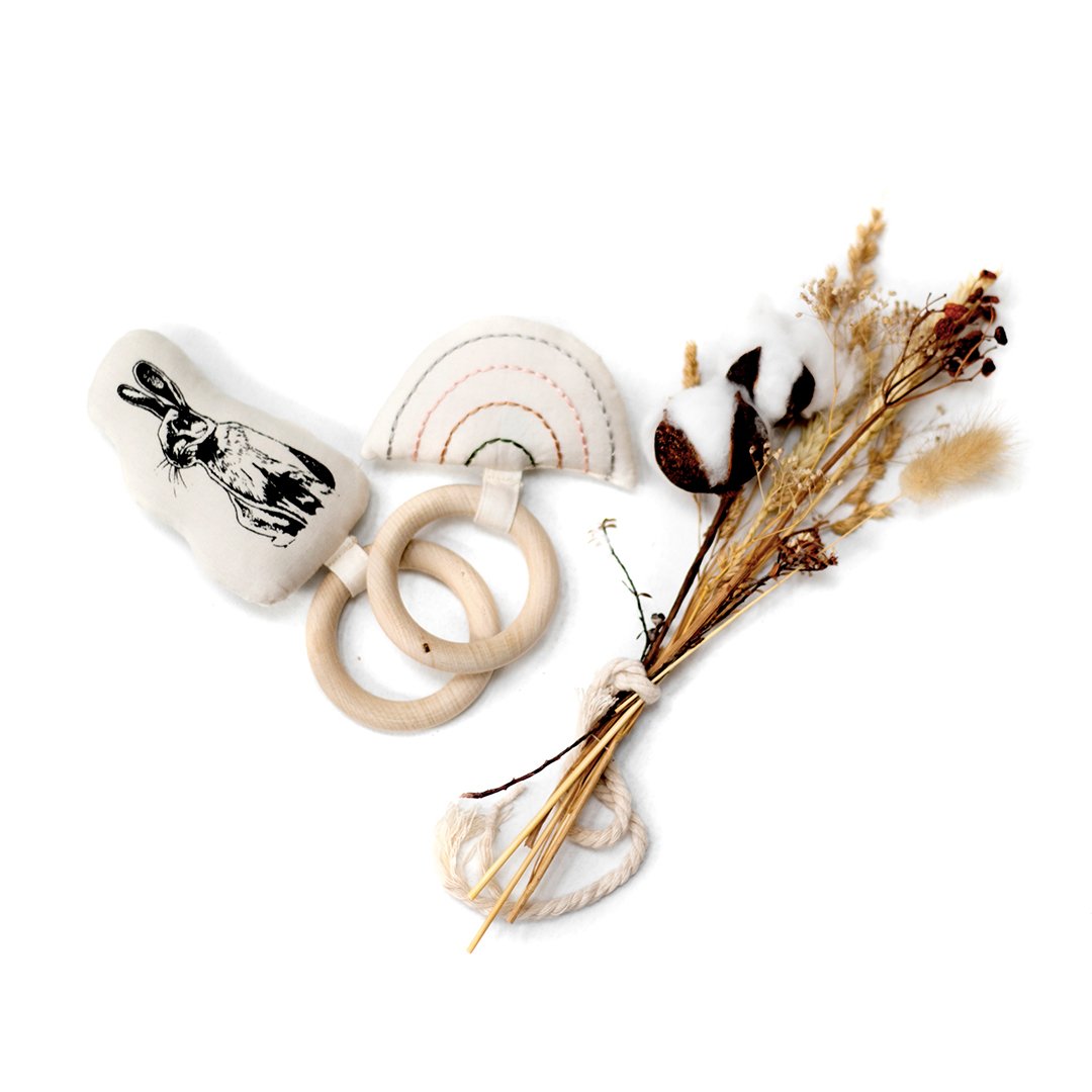 2 maple wood teething rings with organic cotton prints sewing onto maple wood rings. 