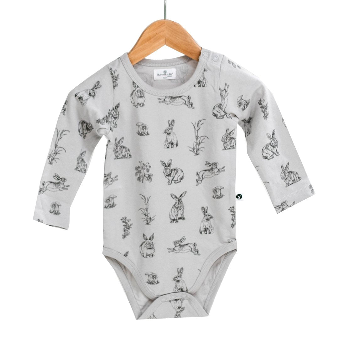 Grey long sleeve organic baby onesies with rabbit print and a dome on each shoulder.